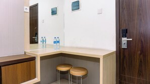 A corner bathroom with a wooden vanity, two stools, and two water bottles on the counter. - Cozy Stay 2Br Annora Living Apartment (Tangerang)