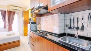 Una cocina moderna con armarios de madera, estufa a gas, pileta de acero inoxidable y salpicadero de azulejos.