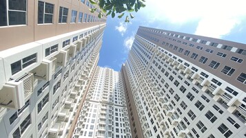 A high-rise building with multiple floors, large windows, and balconies.