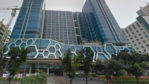 Een modern hotel met een opvallende geometrische gevel, meerdere hoge gebouwen op de achtergrond en een herkenbaar Best Western bord.