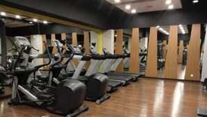 Ett gym med flera löpband och annan träningsutrustning, trägolv och speglar på väggarna.
