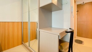 Une salle de bain moderne avec une douche à parois de verre, un meuble-lavabo blanc et une porte en bois.
