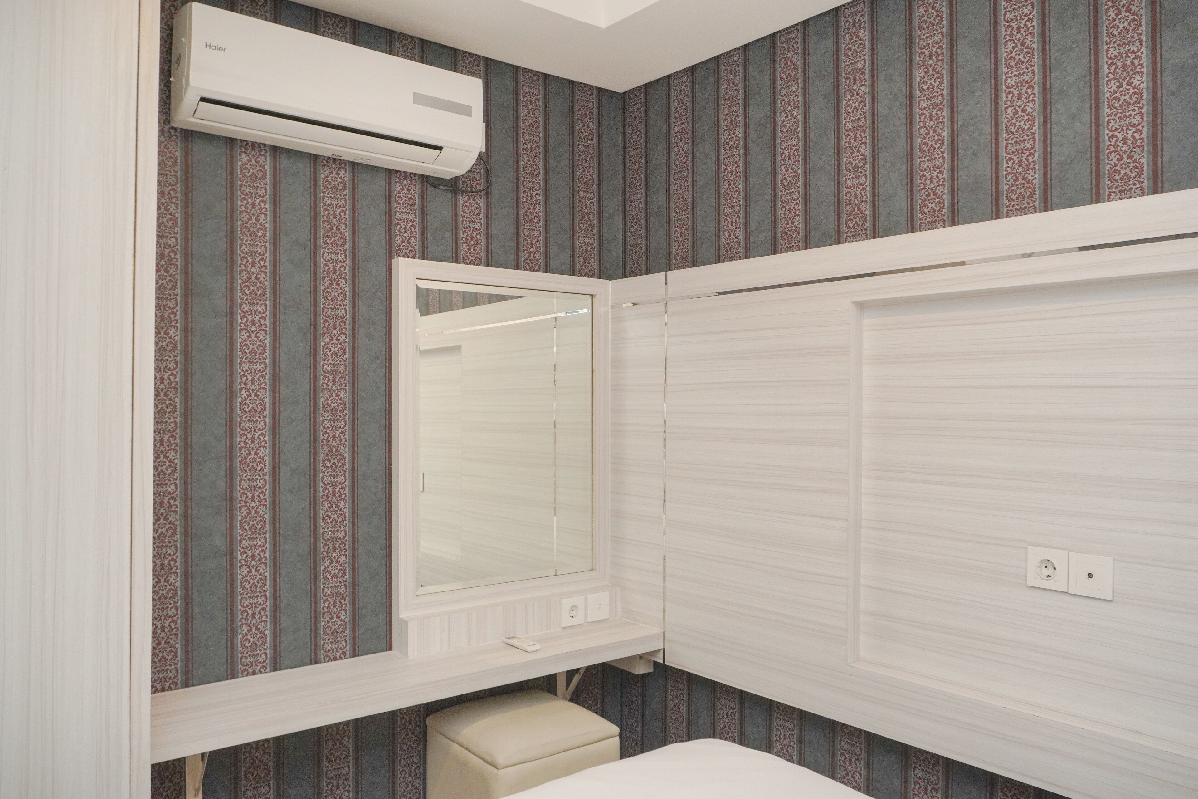 A bathroom with a mirror, a toilet, and a shower area.