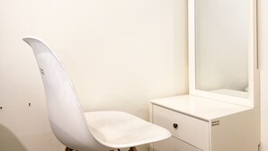 A white vanity with a mirror and a chair. - Homey And Simply Look Studio Meikarta Apartment (Cikarang)