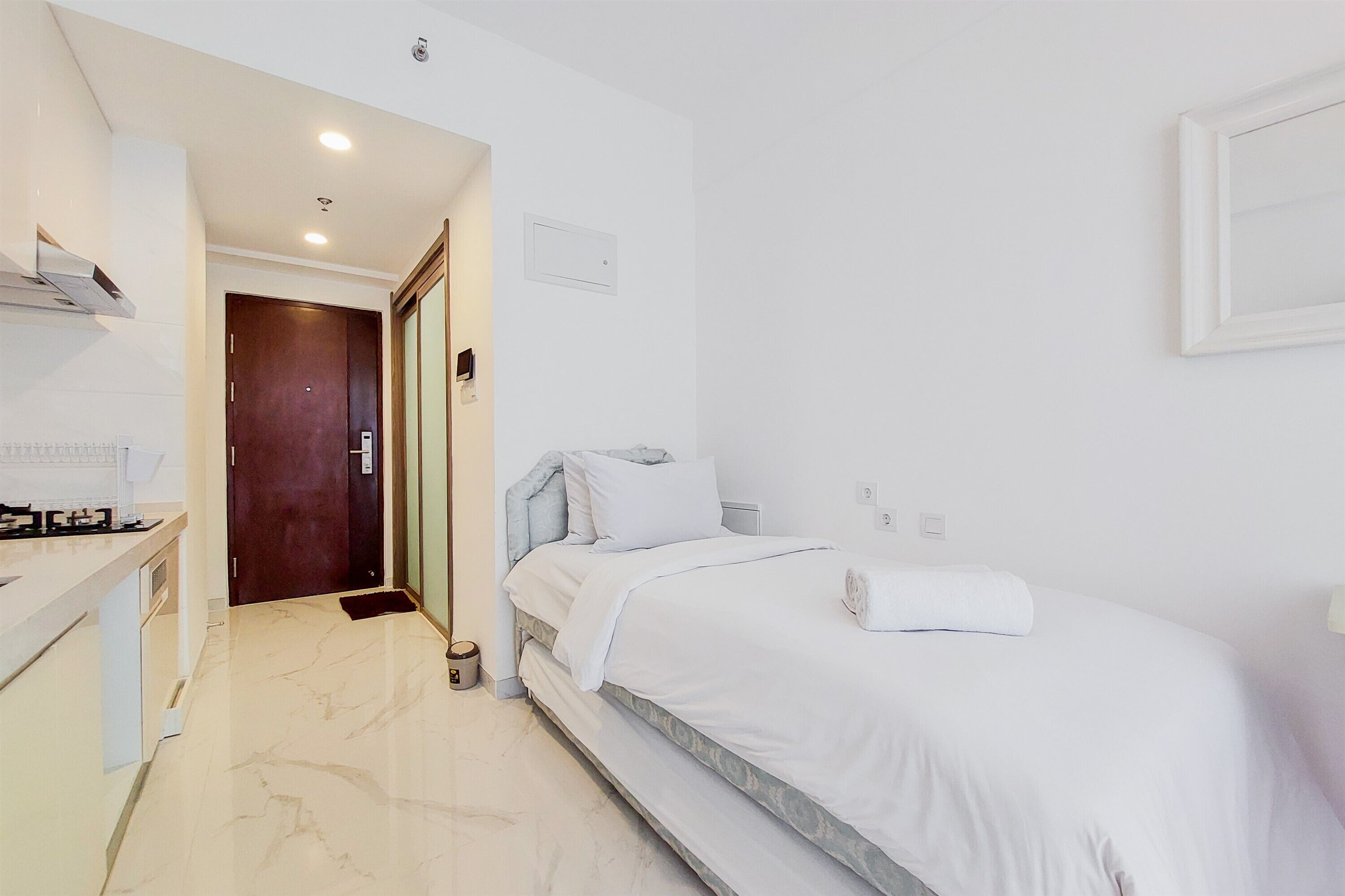 A hotel room with a bed, a desk, and a bathroom.