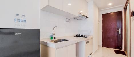 A modern kitchen with a built-in sink, a stove, and a refrigerator.