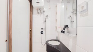A modern bathroom with a black sink, a mirror, and a handheld showerhead. - Good Deal And Comfortable Studio At Sky House Bsd Apartment (Pagedangan)