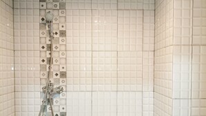 Une salle de bain avec une douche, un lavabo et des carreaux décorés.
