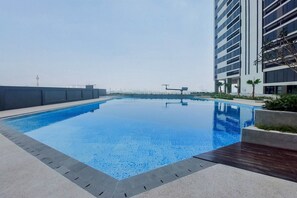 A rooftop swimming pool with a clear view of the city skyline in the background. - Good Deal And Homey Studio Collins Boulevard Apartment (Tangerang)