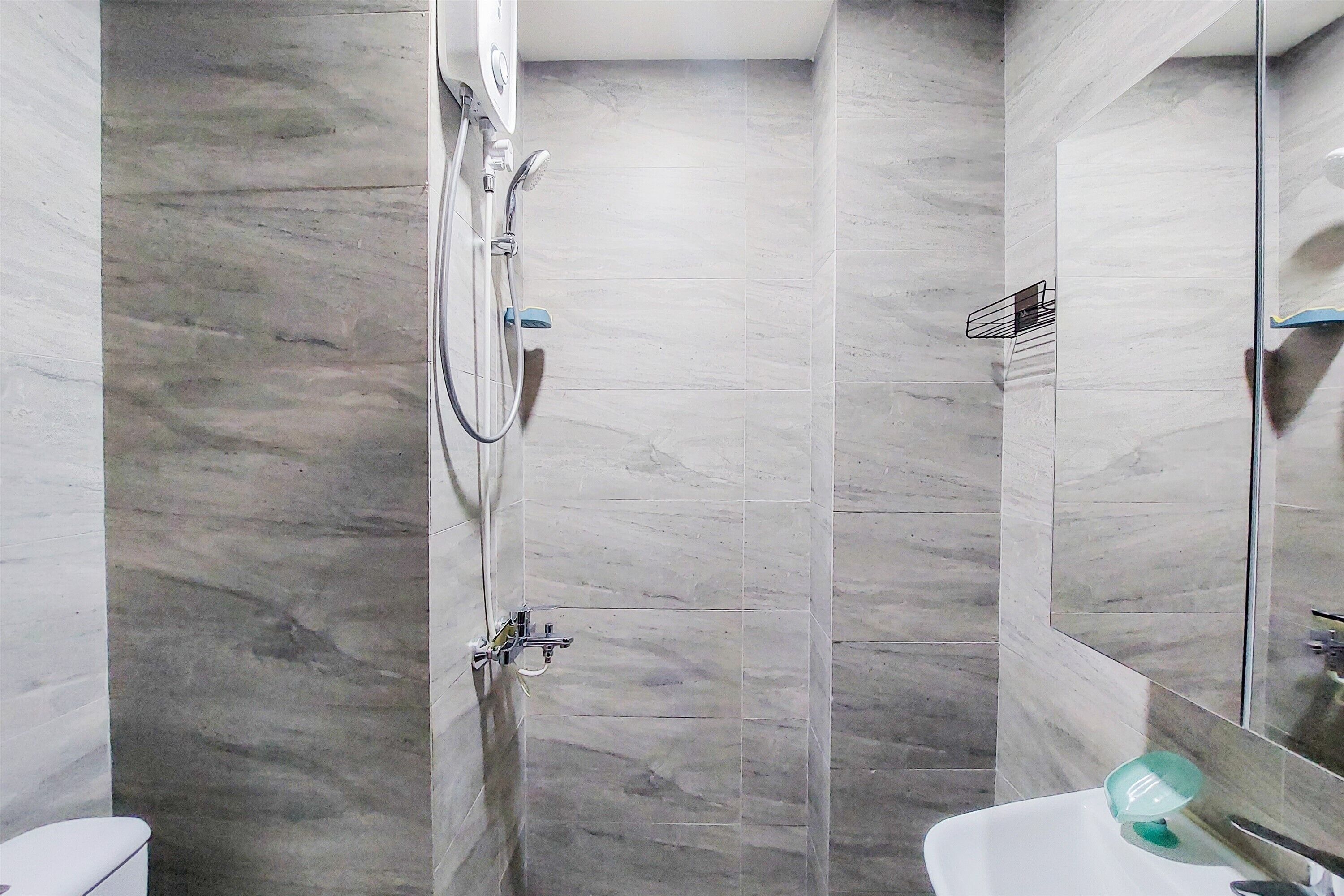 A modern bathroom with a shower, toilet, and sink.