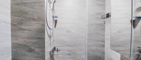 A modern bathroom with a shower, toilet, and sink.