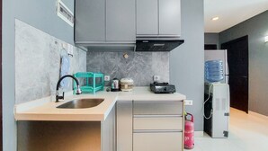 Eine moderne Küche mit einem doppelten Spülbecken, grauen Schränken, einer eingebauten Dunstabzugshaube und einem Wasserspender.