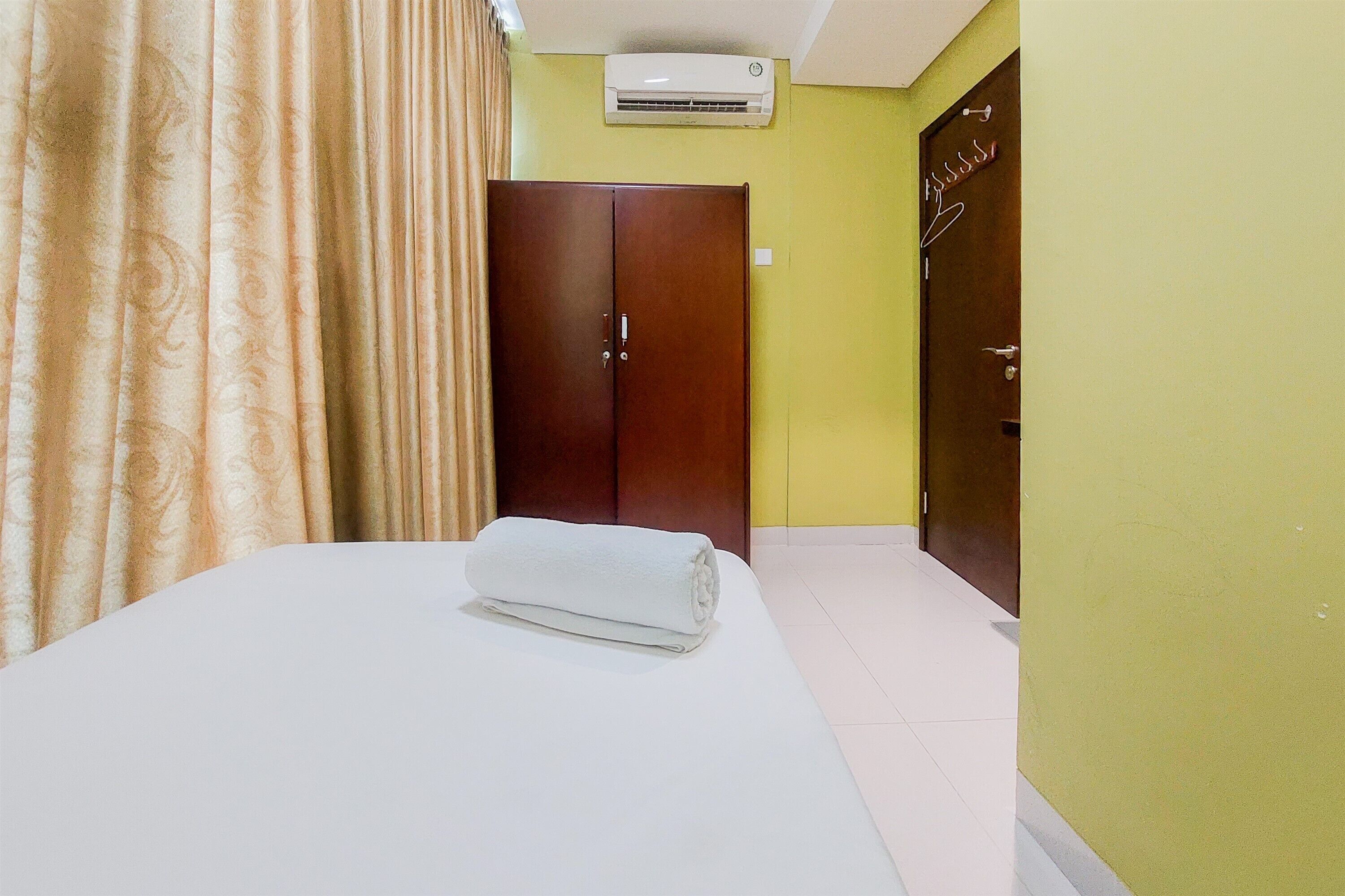 Une chambre d’hôtel équipée d’un lit, d’une armoire et d’un appareil de climatisation.