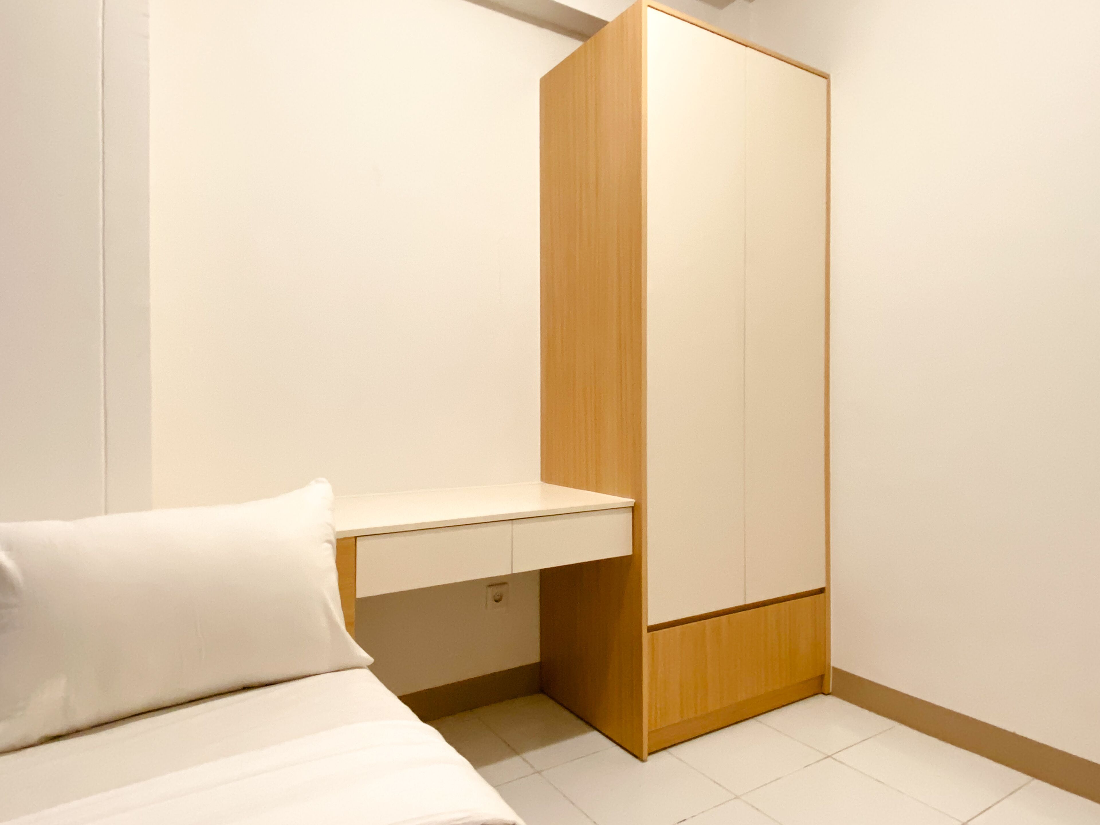 Una camera da letto con un letto, un armadio in legno e una piccola scrivania.