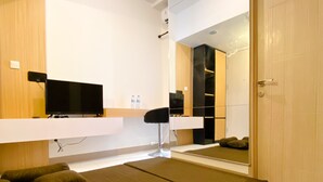 Una camera da letto moderna con un letto, una TV e uno specchio.