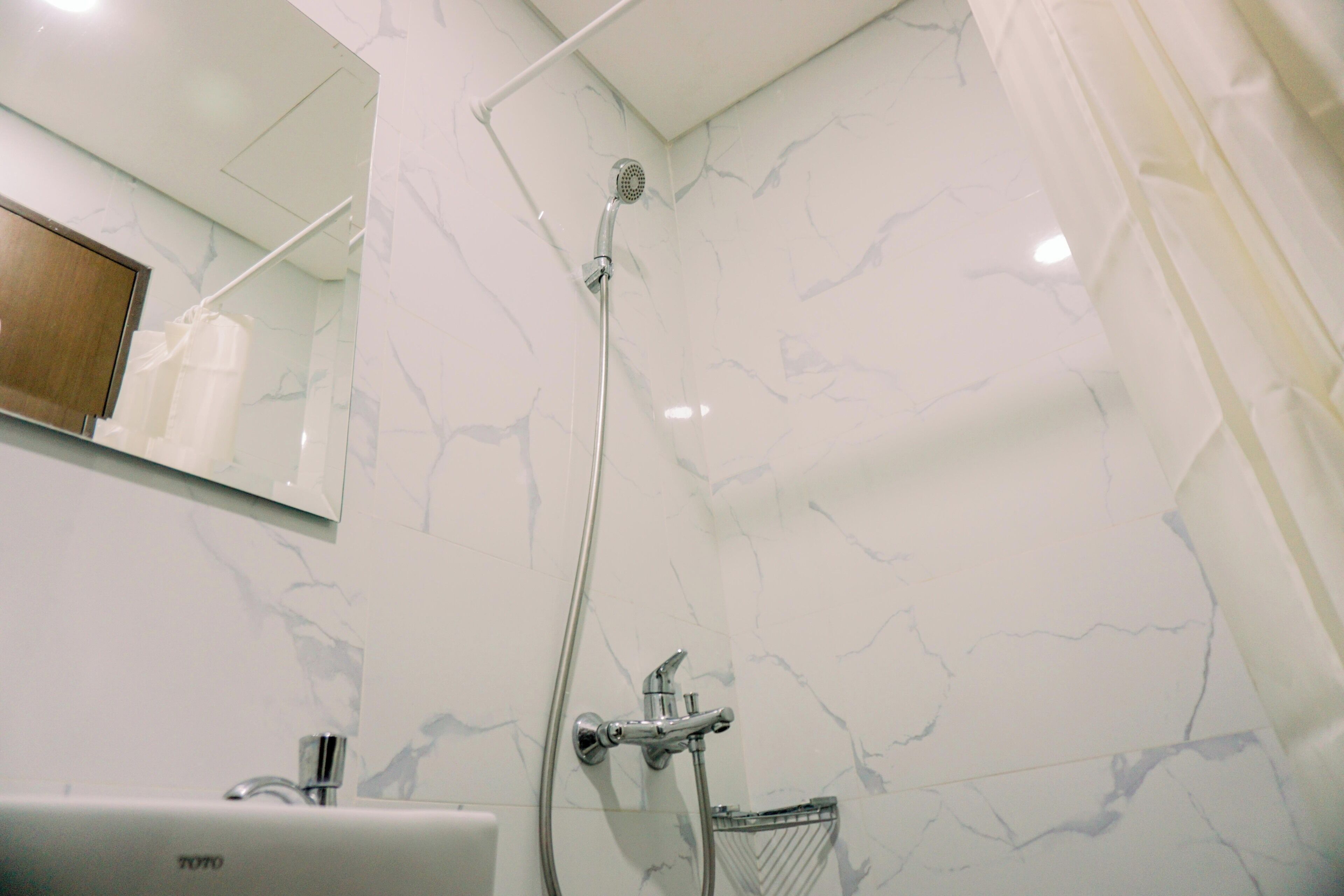 A bathroom with a shower, a sink, and a mirror.