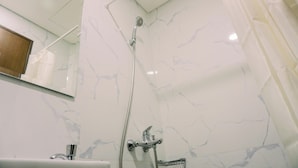 A bathroom with a shower, a sink, and a mirror. - Nice And Modern Studio At 38Th Floor Pacific Garden Apartment (Tangerang)