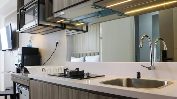 Eine moderne Küche mit Einbau-Mikrowelle, Kaffeemaschine und einem großen Spülbecken.