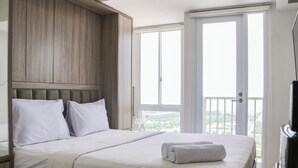 Ein Hotelzimmer mit einem großen Bett, einem hölzernen Kopfteil und einem Balkon mit Blick.