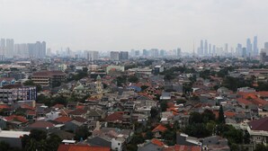 Un quartier urbain densément peuplé, où se côtoient des immeubles résidentiels et commerciaux, dont un bâtiment historique remarquable avec un dôme verdâtre.