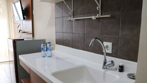 Une salle de bain moderne avec un lavabo blanc, un miroir et un porte-serviettes.