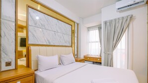 Hotellihuone, jossa on suuri sänky, puiset yöpöydät, marmorista valmistettu sängynpääty, peili ja ikkuna, jossa on verhot.