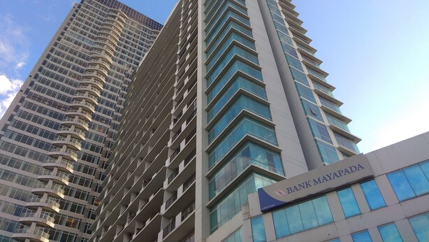 Un moderno edificio de gran altura con un llamativo letrero de 'Bank Mayapada'.