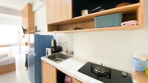 A compact kitchen with a sink, stove, and wooden cabinets.