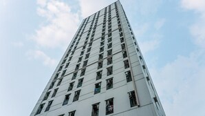 A tall, modern building with a grid of windows and balconies.