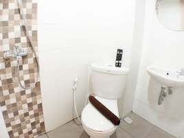 Un baño con inodoro, ducha y lavamanos.