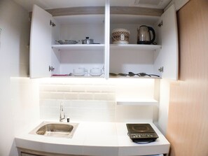 Estudi | Cuina privada | Frigorífic, placa de cuina, arrossera i una taula de menjador