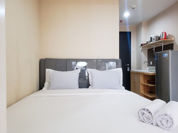 Relax in comfort with a neatly made bed and convenient amenities like a kettle and coffee maker.