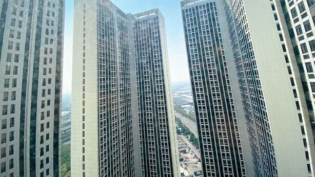 Un edificio de gran altura con fachada enrejada y numerosas ventanas.