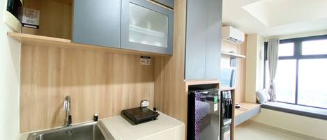 A modern kitchen with a stainless steel sink, wooden cabinets, and a built-in refrigerator.