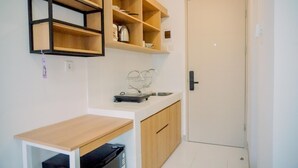Una cocina compacta con armarios de madera, una encimera y una estantería empotrada.
