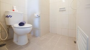 Un baño con inodoro, ducha y radiador.