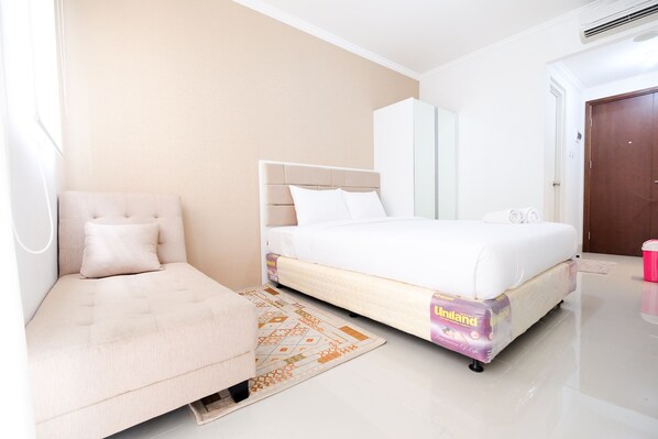 Relax in a serene space with a comfortable bed, sofa, and area rug.