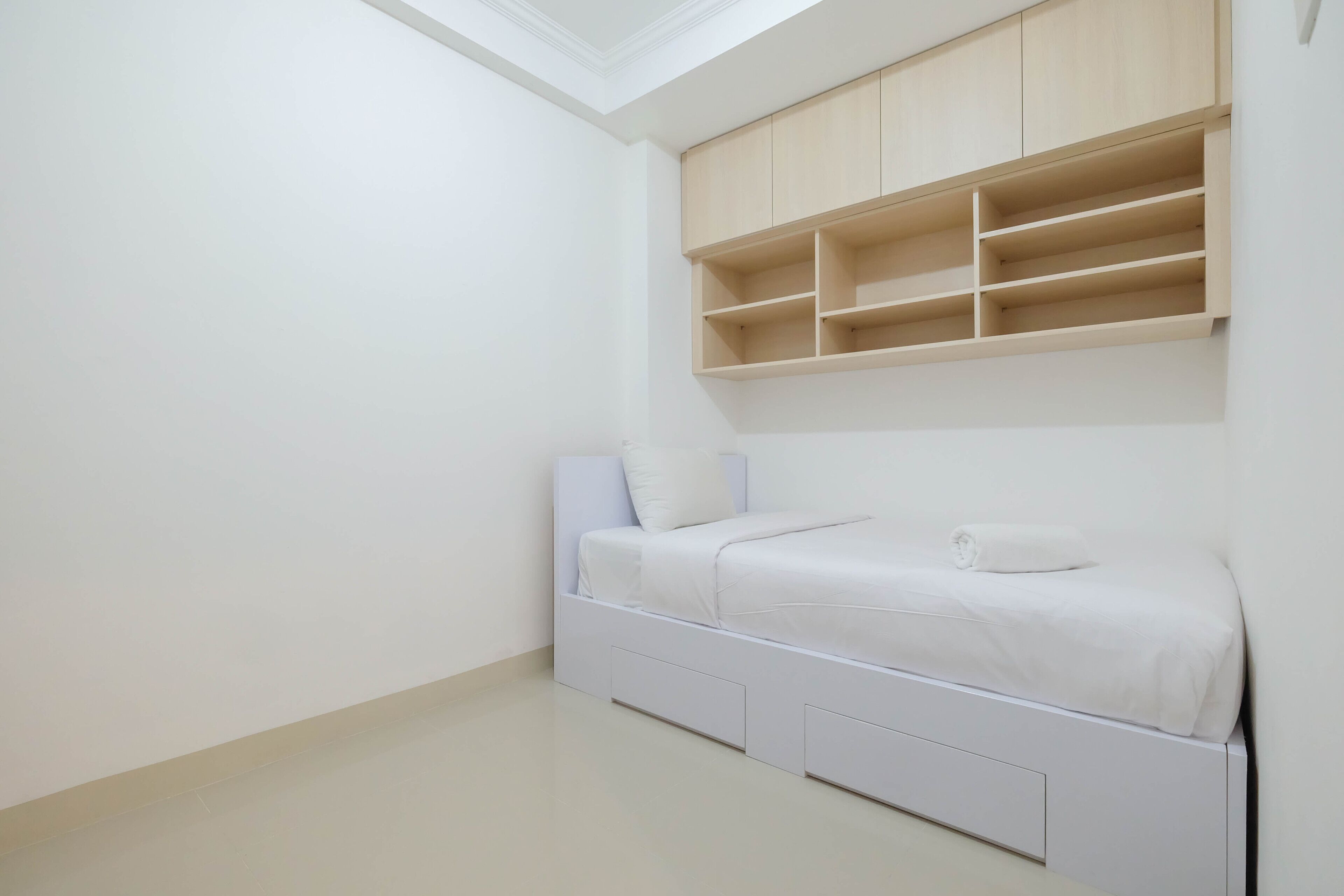 Un dormitorio con cama, estanterías empotradas y tragaluces.