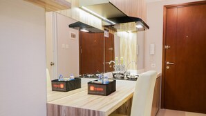 A hotel bathroom with a wooden vanity, a mirror, a sink, and two toiletries boxes labeled 'olivent' and 'travello'. - New Furnished Studio At Signature Park Grande Apartment (Jakarta)