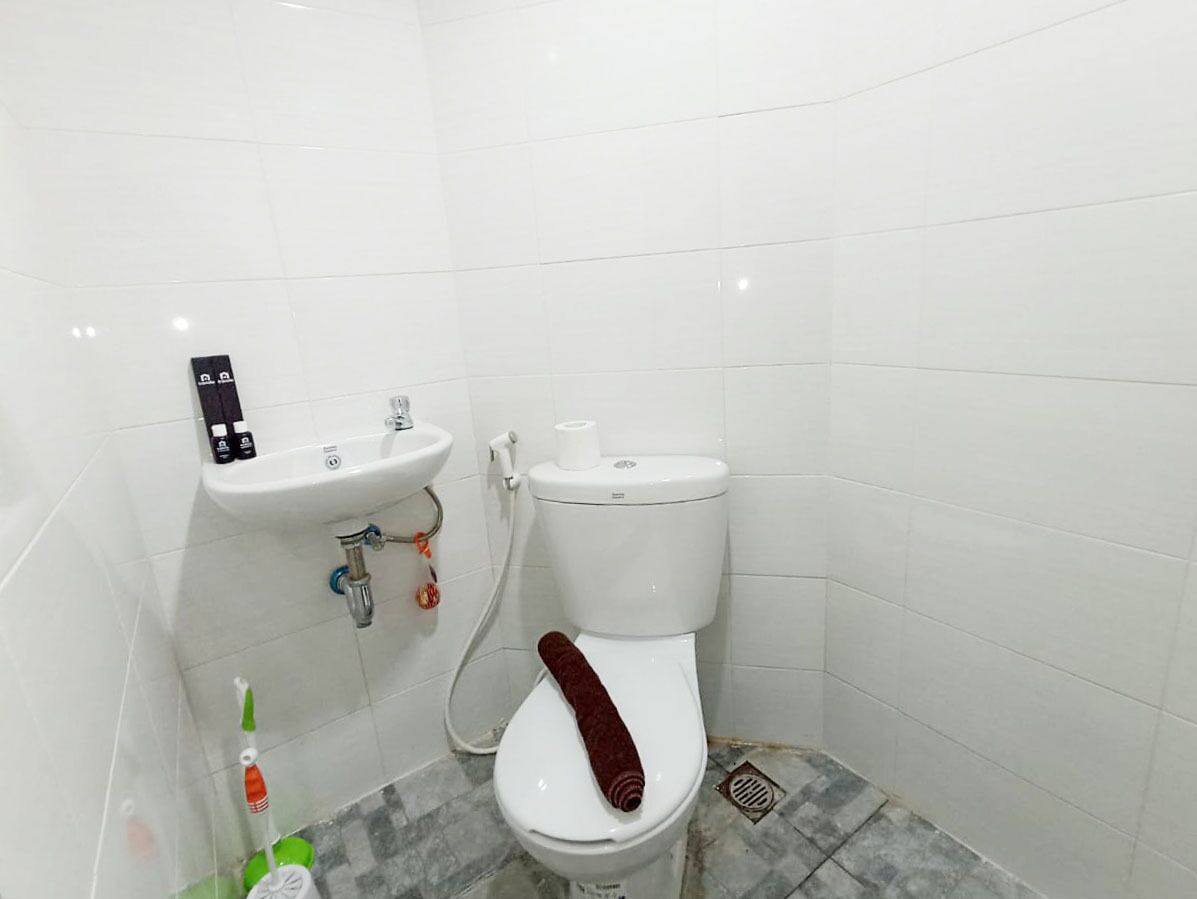 A small bathroom with a white toilet, a sink, and a shower.