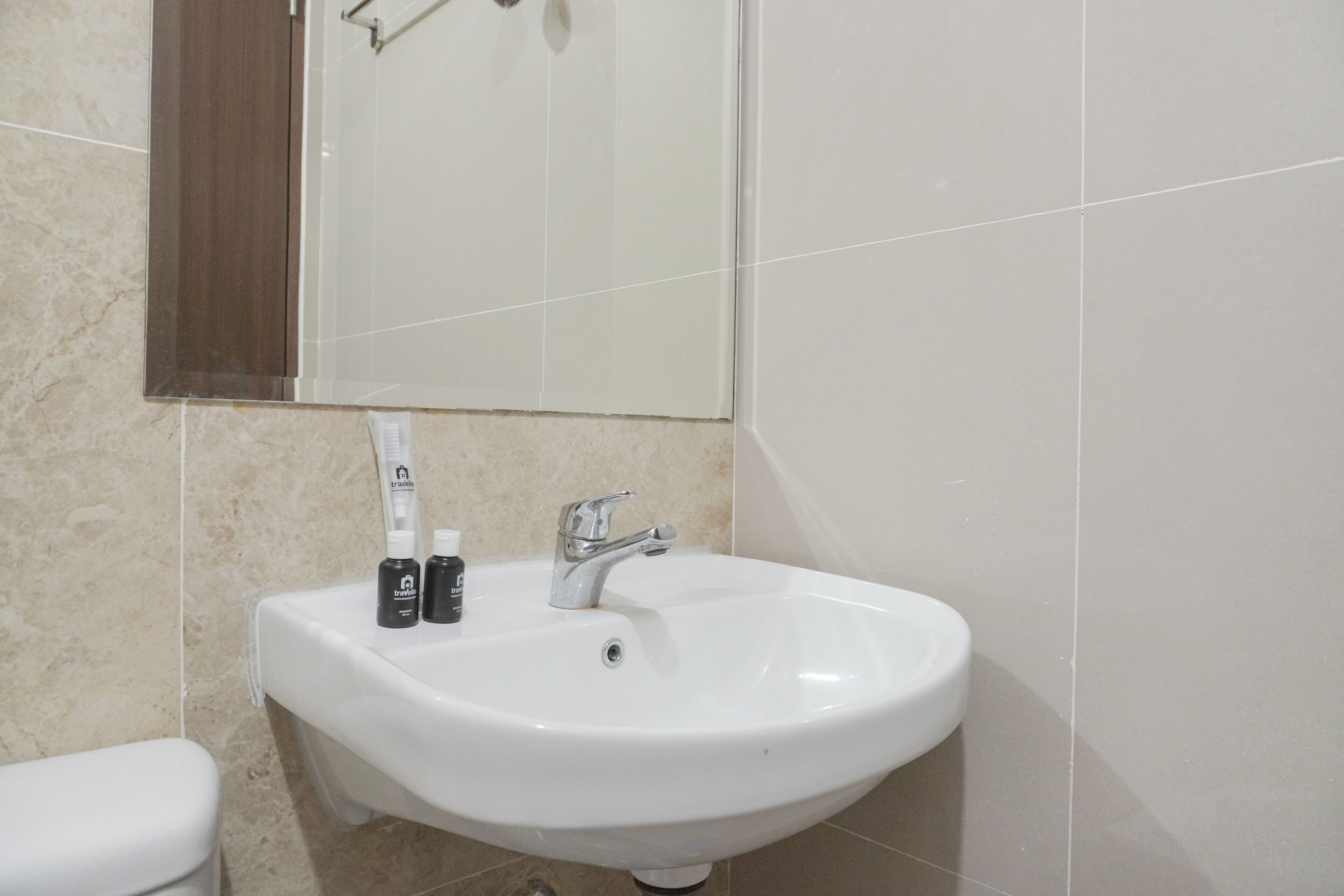 Une salle de bain avec un lavabo blanc, un miroir et deux flacons de savon pour les mains.