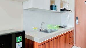 Eine moderne Küche mit weißen Schränken, einer Edelstahl-Spüle und einem kompakten Geschirrspüler.
