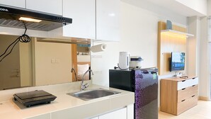 Una cocina moderna con estufa integrada, un lavamanos y un refrigerador.
