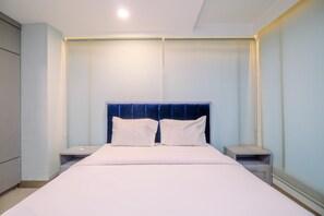 A modern hotel room with a large bed, two bedside tables, and a built-in headboard. - Good Choice And Cozy 2Br Grand Kamala Lagoon Apartment (Bekasi)