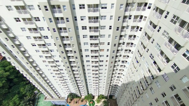 A high-rise residential building with multiple balconies and a rooftop swimming pool. - Stylish 1Br Apartment Parahyangan Residence (Bandung)