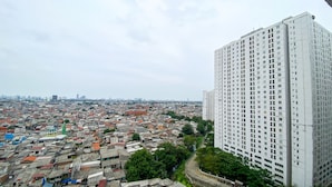 A high-rise building with a dense urban background. - Good Deal And Homey Studio Bassura City Apartment (Jakarta)