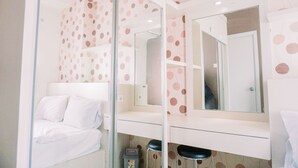 Ein modernes Badezimmer mit einem Bett, einem Spiegel und einer Toilette.
