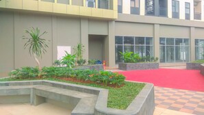 A courtyard with a checkered floor, a red carpet, and a variety of plants. - Good Choice And Restful Studio At Transpark Cibubur Apartment Near Mall (Depok)