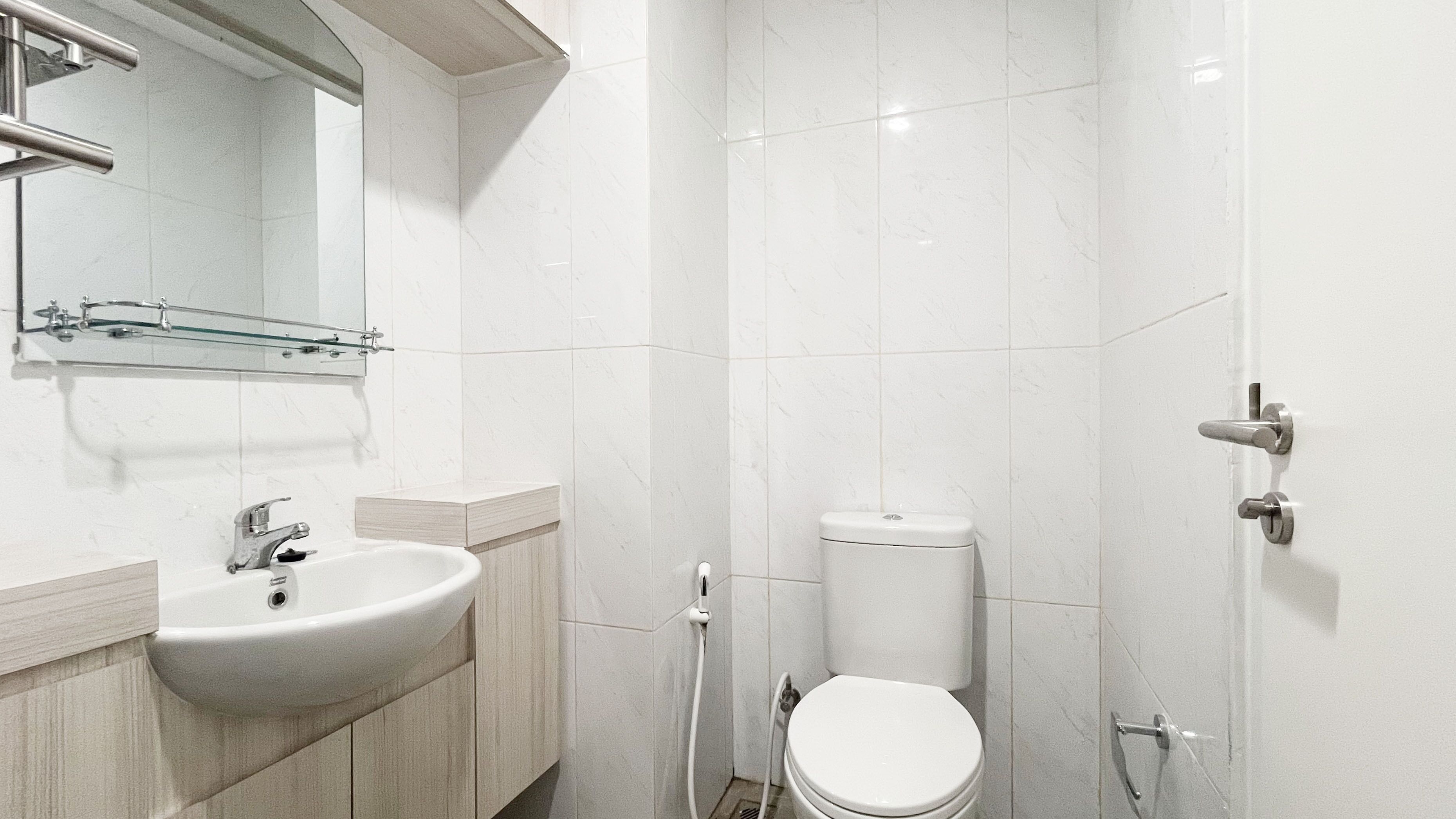 Een badkamer met een wastafel, spiegel, toilet en douche.