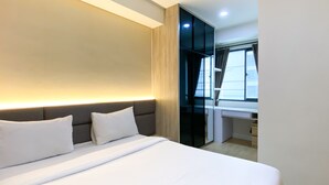 A modern hotel room with a large bed, a bedside table, and a window with curtains. - Good And Modern 2Br Daan Mogot City Apartment (Jakarta)